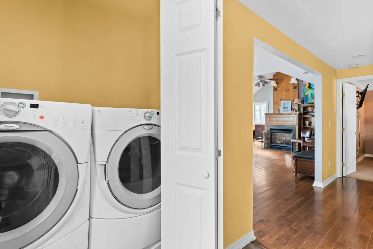 An inviting interior view featuring a washing machine and dryer adjacent to a doorway leading into the living space. The setup conveys the convenience of in-unit laundry, perfect for refreshing after days spent outdoors.